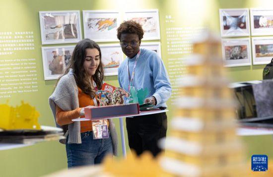 4月10日,在意大利博洛尼亚国际儿童书展上,参观者在中国图书展区翻阅西游记主题立体书。新华社记者 李京 摄