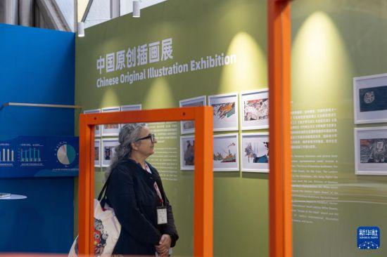 4月10日，在意大利博洛尼亚国际儿童书展上，参观者在中国图书展区观看中国原创插画展。新华社记者 李京 摄