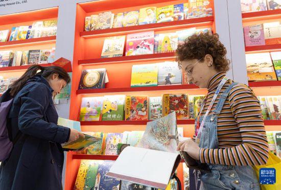 4月10日，在意大利博洛尼亚国际儿童书展上，参观者在中国图书展区翻阅图书。新华社记者 李京 摄