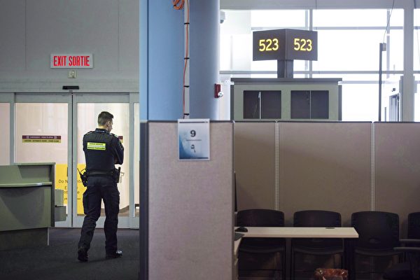 A Canadian Border Services agent stands watch at gate at Pearson International Airport in Toronto on Tuesday, December 8, 2015. A coalition of business leaders in Canada's largest cities is putting pressure on Ottawa to reduce security screening times and cut travelling costs to bolster a prime engine of the country's economy. THE CANADIAN PRESS/Darren Calabrese
