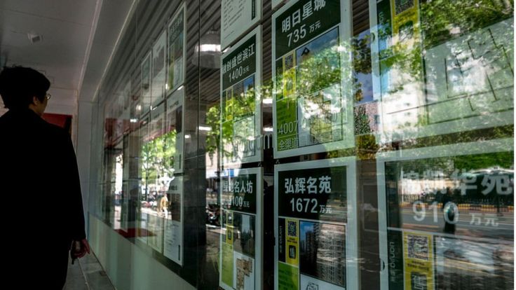 上海，一名路人在中介门外看房。