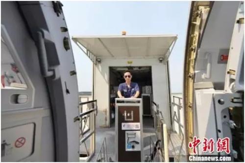 资料图：空乘人员将餐品送上飞机 钟欣 摄