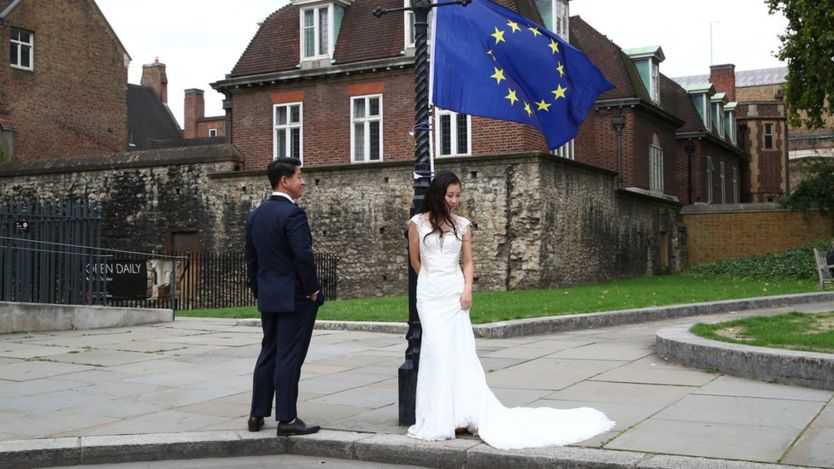 一对中国的新人在伦敦一处抗议脱欧者放置的欧盟旗帜下拍摄婚纱照