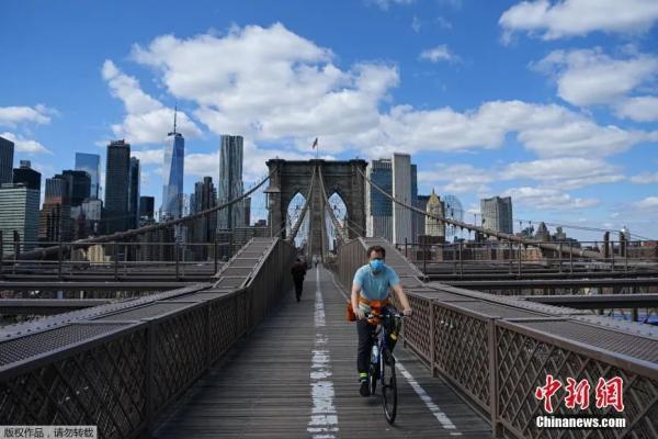 资料图：图为戴着口罩的骑手在纽约布鲁克林大桥上骑行。